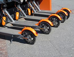 A row of orange and gray e-scooters.