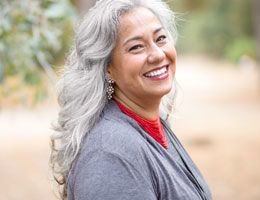 A middle-aged woman smiles at the camera.