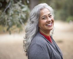 An older woman smiles at the camera.