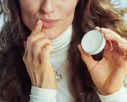 Woman applying lip balm.
