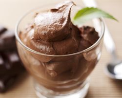 A clear glass containing chocolate mousse.