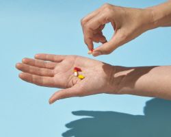 A person counts pills into their outstretched hand