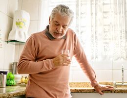 A man leans on a kitchen counter.
