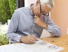 A man doing a crossword puzzle.