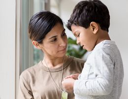 A woman looks at a young boy.