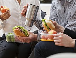 Three office workers eating lunch together.