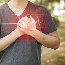  A man with his hands on his chest and a heartbeat graphic superimposed.