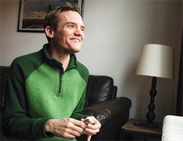 A smiling man looks out a window.