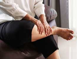 A woman massages her calf.