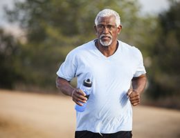 A middle-aged man jogging outside.