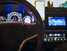 A car dashboard, steering wheel and infotainment system.