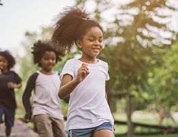 Three kids running outside.