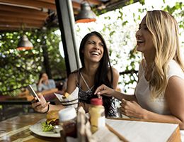 Two young women laughing in a restaurant.