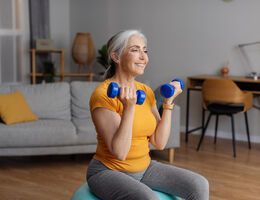 A woman lifts hand weights.