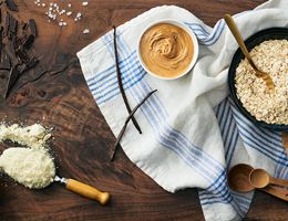 Bowl of oats, crushed chocolate bar, and almond butter.