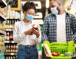 A couple in a grocery store wearing face masks.