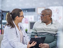 A female doctor is talking to an older man.