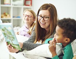 A mom reading to her two young children.