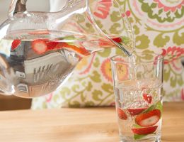 Jar and glass of strawberry agua fresca.