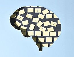 Illustration of a brain with blank notes and notes with questions marks posted inside.