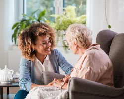  A young woman and an older woman talk while holding hands.