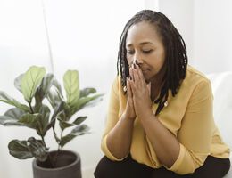 A woman rests her chin on her hands.