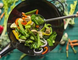 A variety of vegetables in a stir-fry pan.