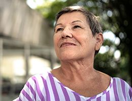 A woman in a striped shirt outdoors.