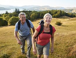 An aging couple on a hike. 