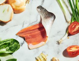 Fillet of fish surrounded by ingredients in recipe.