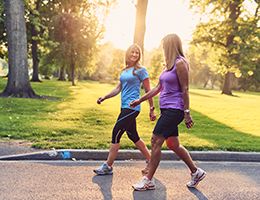 Two women walking in a park.