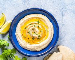 A blue plate with hummus.