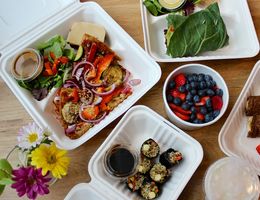 Takeout containers with vegetarian meals and desserts.