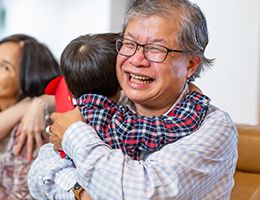 Grandparents hug their grandchildren.