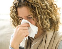 Woman blowing her nose.