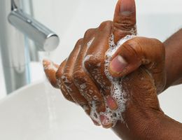 Soapy hands under a sink.