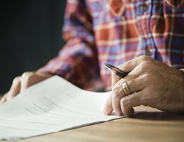 A person holding a pen reviews important documents.