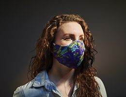 A woman wearing a colorful face mask.