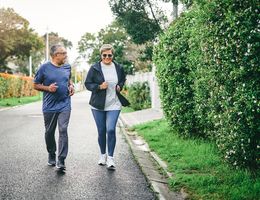 A man and woman walk on a quiet street