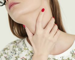 A woman wraps her hand around her throat