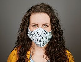 A woman wearing a blue and white face mask.