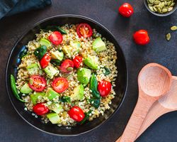 A black bowl of quinoa with avocado.