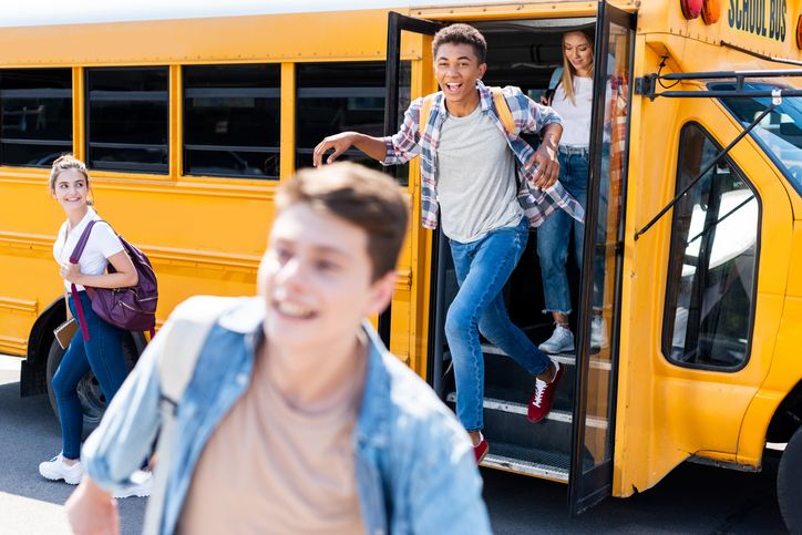 Middle School Students Exiting A Yellow School Bus
