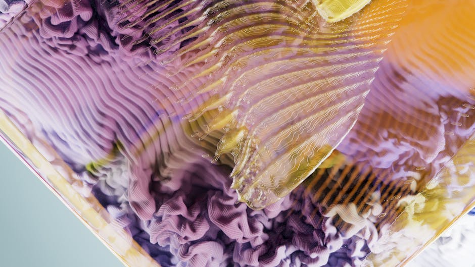 Close-up of abstract, wavy, purple, and yellow textures resembling layered fabric or rippling surfaces.