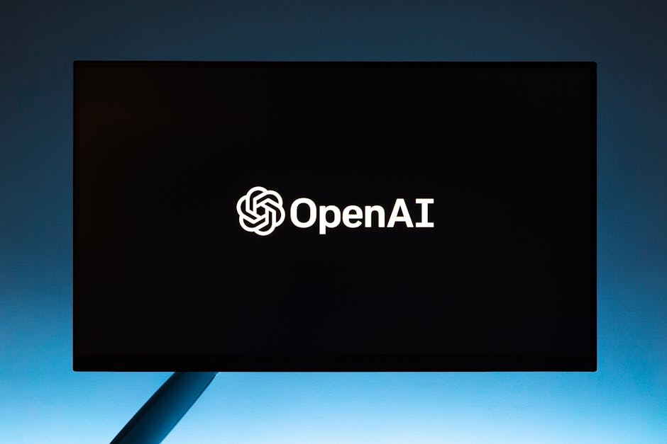 A computer screen displaying the OpenAI logo against a dark background with a blue gradient. The image is focused on the screen and the prominent logo in the center.
