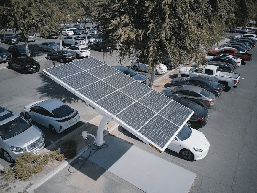 A solar-powered electric vehicle charging station in a parking lot with multiple cars.