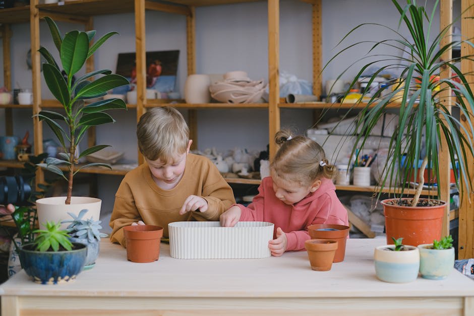 Two children are engaged in a gardening activity at a table filled with pots and plants.