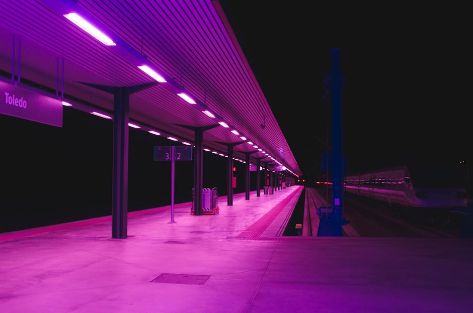 A brightly lit, empty train station at night, labeled 
