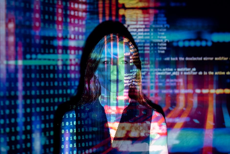 A woman stands in front of a screen with colorful projections of binary numbers and code, symbolizing technology and digital themes.