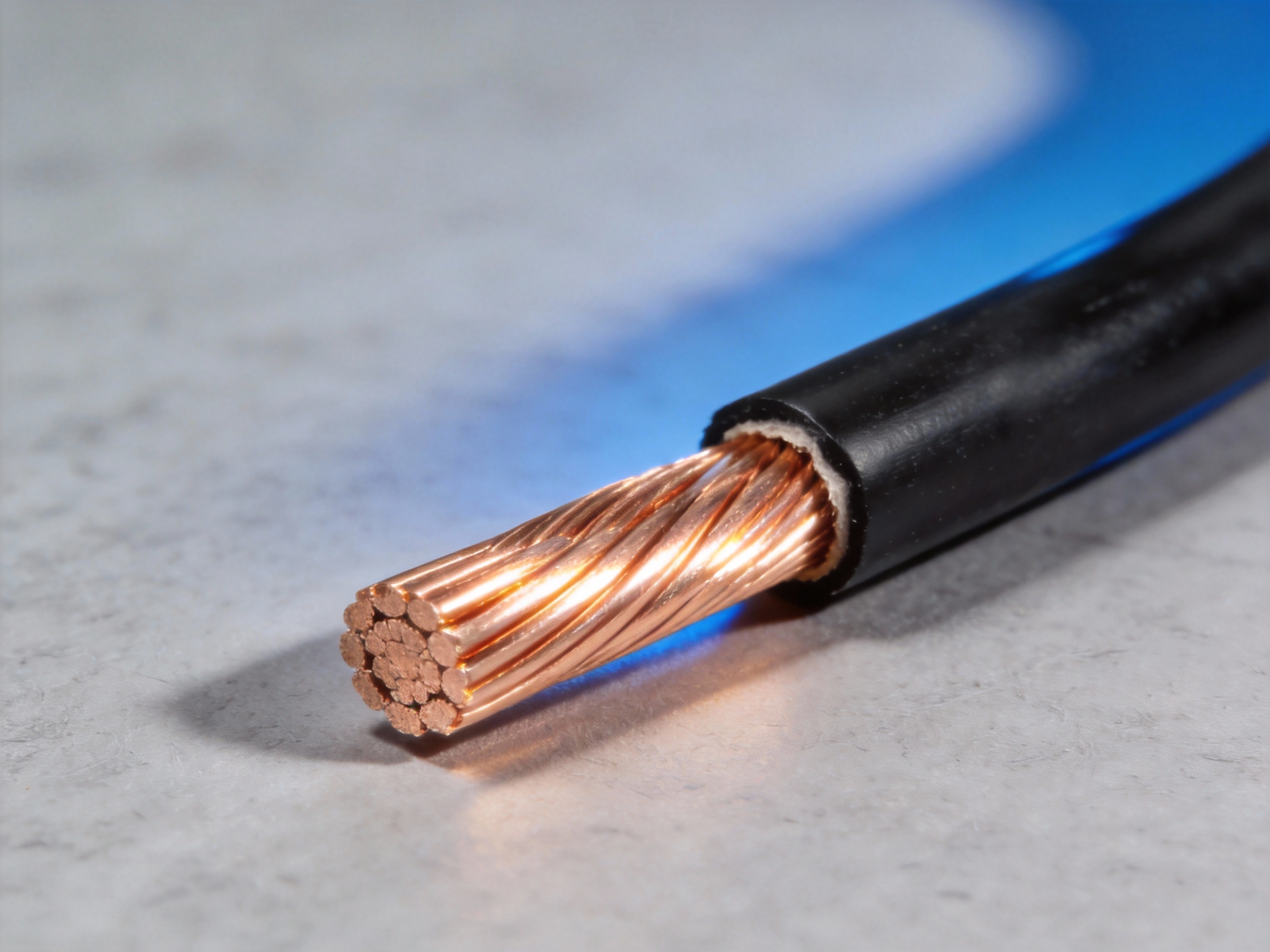 Close-up of a thick 4 AWG copper electrical wire with its insulation cut away to show the conductor size